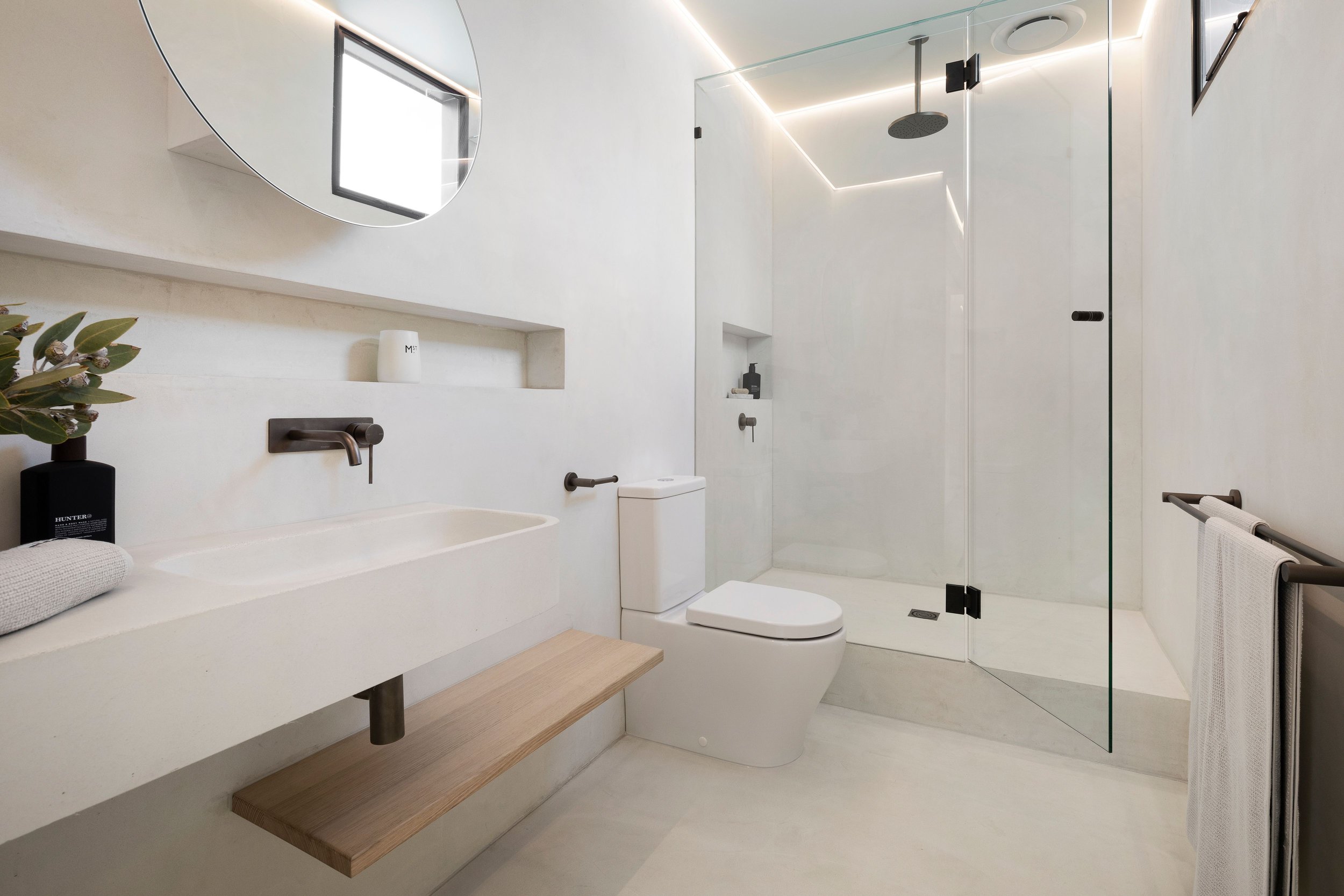 Close-up view of a modern bathroom interior featuring smooth microcement walls.