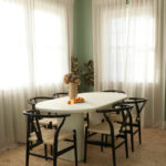 Stylish dining room featuring NG Cork Flooring with a white oval table and black Wishbone chairs