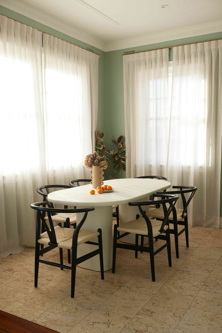 Stylish dining room featuring NG Cork Flooring with a white oval table and black Wishbone chairs